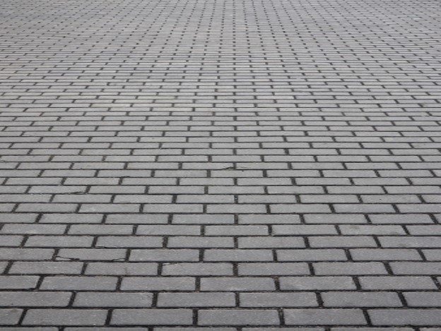 Gray brick paver driveway installed in a running bond pattern for residential property in Columbia Station, OH