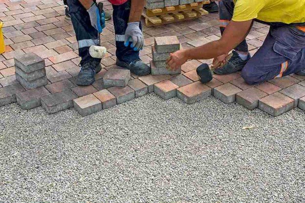 Concrete contractors installing paver driveway edge with gravel base preparation in Parma Heights, OH