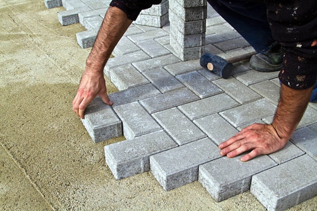 Contractor installing concrete pavers for patio construction on a compacted base in Parma Heights, OH