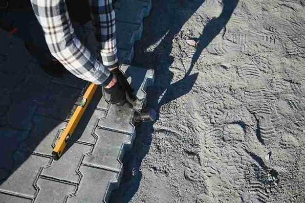 Stamped concrete installation with worker shaping and finishing textured surface in Parma Heights, OH